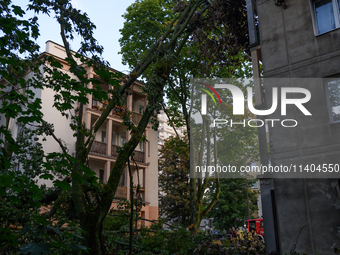 A fallen tree is leaning on a residential building in the Mokotow district after an overnight storm is hitting Warsaw, Poland, on July 13, 2...