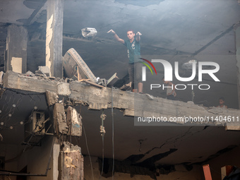 Palestinians are assessing the damage following an Israeli strike in the Nuseirat refugee camp in the central Gaza Strip on July 13, 2024, a...