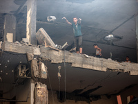 Palestinians are assessing the damage following an Israeli strike in the Nuseirat refugee camp in the central Gaza Strip on July 13, 2024, a...