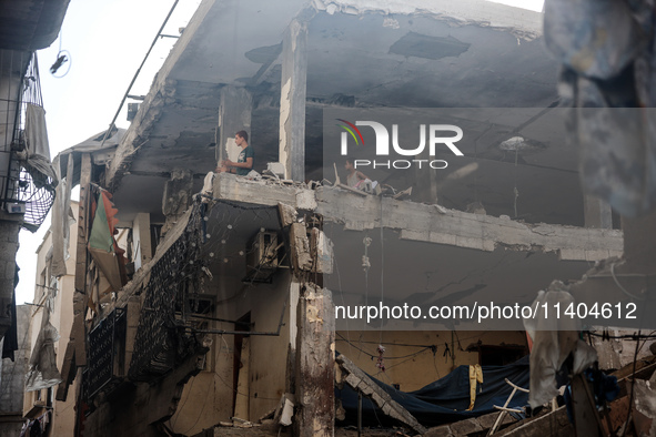 Palestinians are assessing the damage following an Israeli strike in the Nuseirat refugee camp in the central Gaza Strip on July 13, 2024, a...