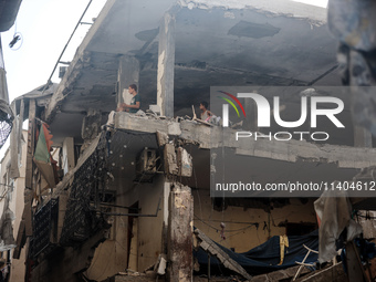 Palestinians are assessing the damage following an Israeli strike in the Nuseirat refugee camp in the central Gaza Strip on July 13, 2024, a...