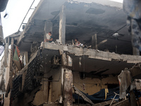 Palestinians are assessing the damage following an Israeli strike in the Nuseirat refugee camp in the central Gaza Strip on July 13, 2024, a...