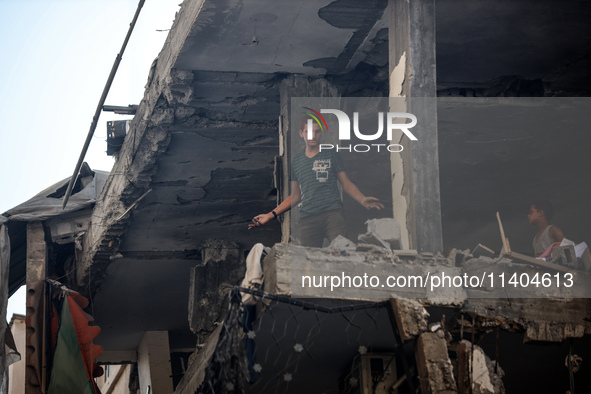 Palestinians are assessing the damage following an Israeli strike in the Nuseirat refugee camp in the central Gaza Strip on July 13, 2024, a...