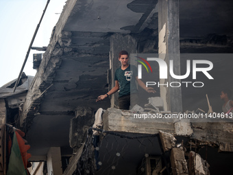 Palestinians are assessing the damage following an Israeli strike in the Nuseirat refugee camp in the central Gaza Strip on July 13, 2024, a...