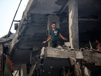 Palestinians are assessing the damage following an Israeli strike in the Nuseirat refugee camp in the central Gaza Strip on July 13, 2024, a...