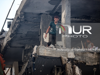 Palestinians are assessing the damage following an Israeli strike in the Nuseirat refugee camp in the central Gaza Strip on July 13, 2024, a...