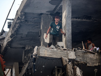 Palestinians are assessing the damage following an Israeli strike in the Nuseirat refugee camp in the central Gaza Strip on July 13, 2024, a...