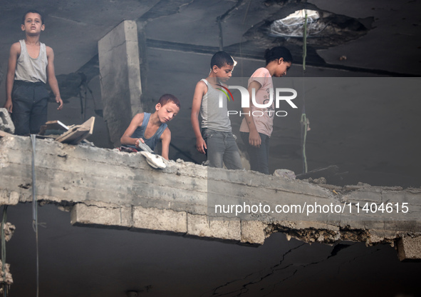 Palestinians are assessing the damage following an Israeli strike in the Nuseirat refugee camp in the central Gaza Strip on July 13, 2024, a...