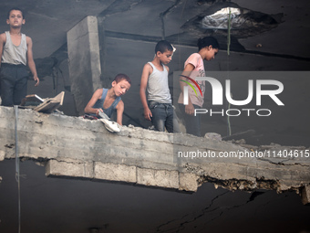 Palestinians are assessing the damage following an Israeli strike in the Nuseirat refugee camp in the central Gaza Strip on July 13, 2024, a...