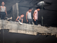 Palestinians are assessing the damage following an Israeli strike in the Nuseirat refugee camp in the central Gaza Strip on July 13, 2024, a...