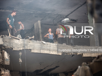 Palestinians are assessing the damage following an Israeli strike in the Nuseirat refugee camp in the central Gaza Strip on July 13, 2024, a...