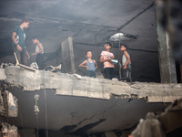 Palestinians are assessing the damage following an Israeli strike in the Nuseirat refugee camp in the central Gaza Strip on July 13, 2024, a...