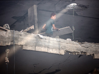 A Palestinian young man is checking the damage in a house hit by Israeli bombardment in Nuseirat, in the central Gaza Strip, on July 13, 202...