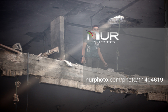 A Palestinian young man is checking the damage in a house hit by Israeli bombardment in Nuseirat, in the central Gaza Strip, on July 13, 202...