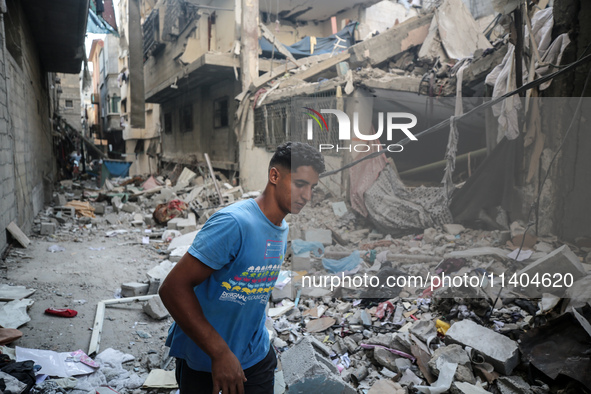 A Palestinian young man is checking the damage in a house hit by Israeli bombardment in Nuseirat, in the central Gaza Strip, on July 13, 202...