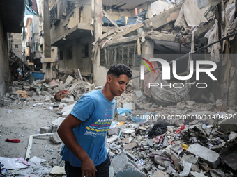 A Palestinian young man is checking the damage in a house hit by Israeli bombardment in Nuseirat, in the central Gaza Strip, on July 13, 202...