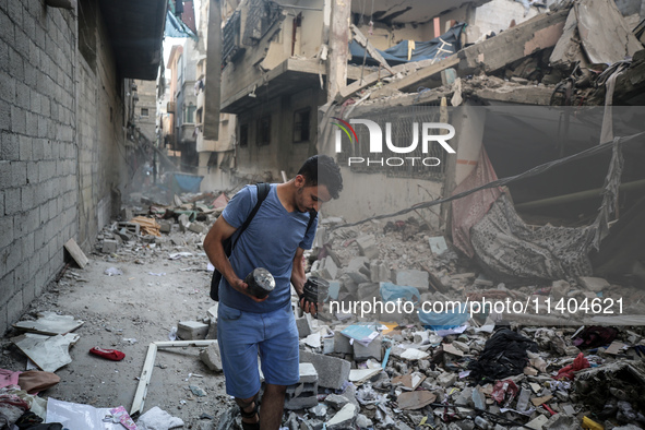 A Palestinian young man is checking the damage in a house hit by Israeli bombardment in Nuseirat, in the central Gaza Strip, on July 13, 202...