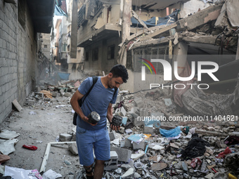 A Palestinian young man is checking the damage in a house hit by Israeli bombardment in Nuseirat, in the central Gaza Strip, on July 13, 202...