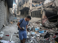 A Palestinian young man is checking the damage in a house hit by Israeli bombardment in Nuseirat, in the central Gaza Strip, on July 13, 202...