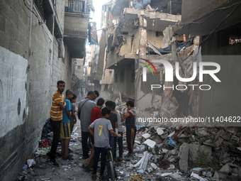 Palestinians are assessing the damage following an Israeli strike in the Nuseirat refugee camp in the central Gaza Strip on July 13, 2024, a...