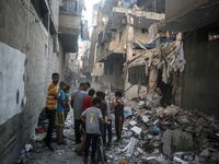 Palestinians are assessing the damage following an Israeli strike in the Nuseirat refugee camp in the central Gaza Strip on July 13, 2024, a...