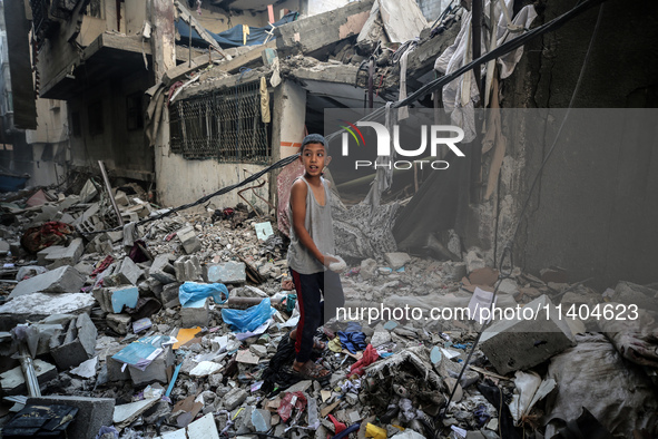 A Palestinian boy is checking the damage in a house hit by Israeli bombardment in Nuseirat in the central Gaza Strip on July 13, 2024, amid...