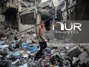 A Palestinian boy is checking the damage in a house hit by Israeli bombardment in Nuseirat in the central Gaza Strip on July 13, 2024, amid...