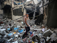 A Palestinian boy is checking the damage in a house hit by Israeli bombardment in Nuseirat in the central Gaza Strip on July 13, 2024, amid...