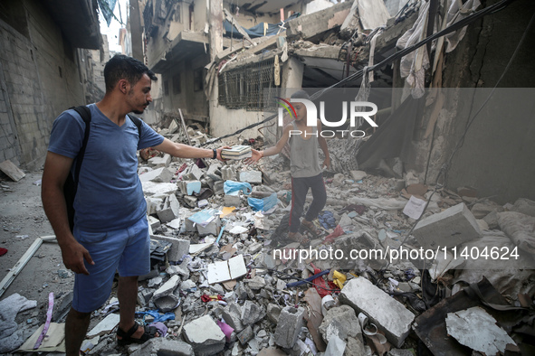 Palestinians are assessing the damage following an Israeli strike in the Nuseirat refugee camp in the central Gaza Strip on July 13, 2024, a...