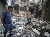 Palestinians are assessing the damage following an Israeli strike in the Nuseirat refugee camp in the central Gaza Strip on July 13, 2024, a...