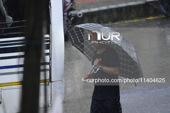 A pedestrian is traveling in the heavy rainfall with an umbrella in Kirtipur, Kathmandu, Nepal, on July 12, 2024. 