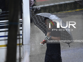 A pedestrian is traveling in the heavy rainfall with an umbrella in Kirtipur, Kathmandu, Nepal, on July 12, 2024. (