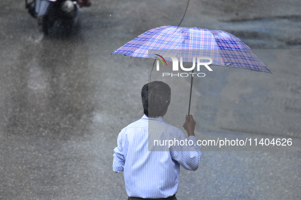 A pedestrian is traveling in the heavy rainfall with an umbrella in Kirtipur, Kathmandu, Nepal, on July 12, 2024. 