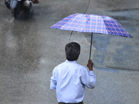 A pedestrian is traveling in the heavy rainfall with an umbrella in Kirtipur, Kathmandu, Nepal, on July 12, 2024. (