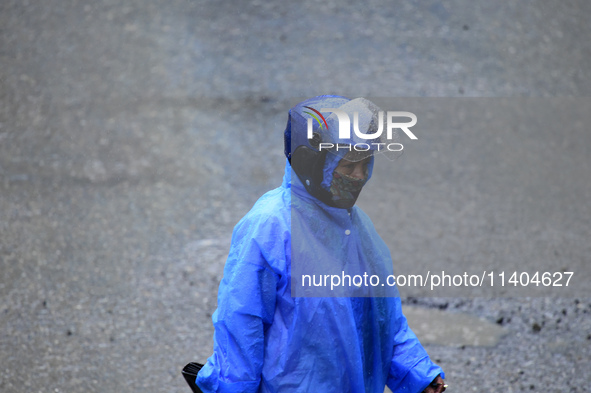 A pedestrian is traveling in the heavy rainfall in Kirtipur, Kathmandu, Nepal, on July 12, 2024. 