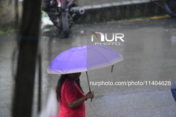 A pedestrian is traveling in the heavy rainfall with an umbrella in Kirtipur, Kathmandu, Nepal, on July 12, 2024. 