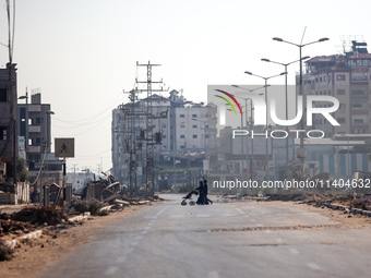 Palestinians are walking on Salah al-Din Road in the Nuseirat refugee camp in the central Gaza Strip on July 13, 2024, amid the ongoing conf...