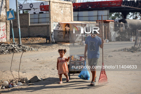 Palestinians are walking on Salah al-Din Road in the Nuseirat refugee camp in the central Gaza Strip on July 13, 2024, amid the ongoing conf...