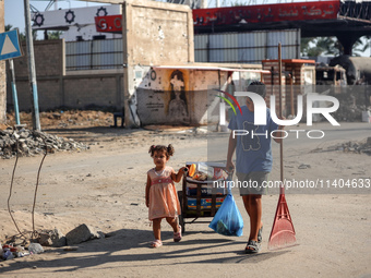 Palestinians are walking on Salah al-Din Road in the Nuseirat refugee camp in the central Gaza Strip on July 13, 2024, amid the ongoing conf...