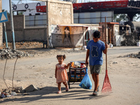 Palestinians are walking on Salah al-Din Road in the Nuseirat refugee camp in the central Gaza Strip on July 13, 2024, amid the ongoing conf...