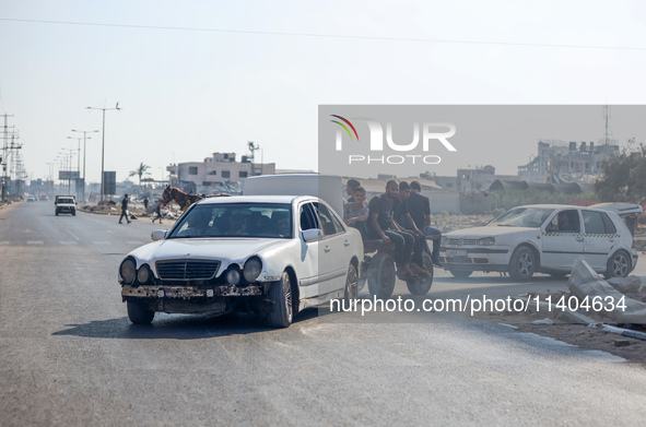 Palestinians are walking on Salah al-Din Road in the Nuseirat refugee camp in the central Gaza Strip on July 13, 2024, amid the ongoing conf...