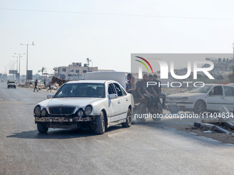 Palestinians are walking on Salah al-Din Road in the Nuseirat refugee camp in the central Gaza Strip on July 13, 2024, amid the ongoing conf...