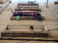 A Palestinian boy is looking out the window of his house in the Nuseirat refugee camp in the central Gaza Strip on July 13, 2024, amid the o...