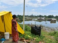 A flood-affected woman is looking at her partially submerged house after heavy rains in Nagaon District of Assam, India, on July 13, 2024. (