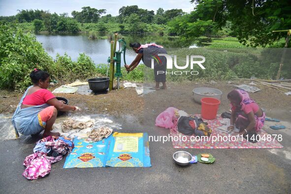 Women are washing their clothes near their makeshift camp in Nagaon District of Assam, India, on July 13, 2024. 