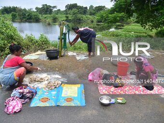 Women are washing their clothes near their makeshift camp in Nagaon District of Assam, India, on July 13, 2024. (