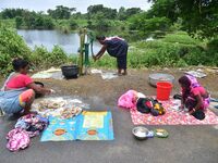 Women are washing their clothes near their makeshift camp in Nagaon District of Assam, India, on July 13, 2024. (