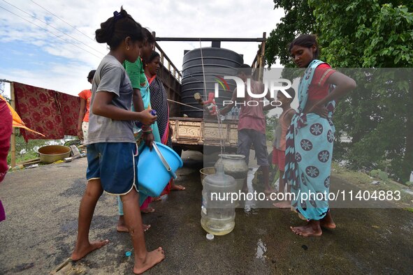 Flood-affected villagers are collecting drinking water from a relief camp conducted by the Public Health Centre (PHC) in Jakhalabandha, Naga...