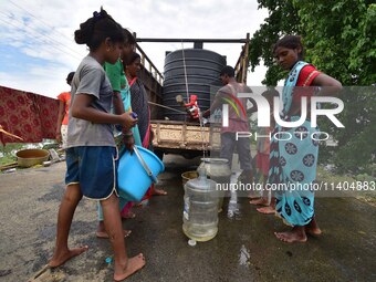 Flood-affected villagers are collecting drinking water from a relief camp conducted by the Public Health Centre (PHC) in Jakhalabandha, Naga...