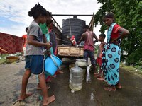 Flood-affected villagers are collecting drinking water from a relief camp conducted by the Public Health Centre (PHC) in Jakhalabandha, Naga...